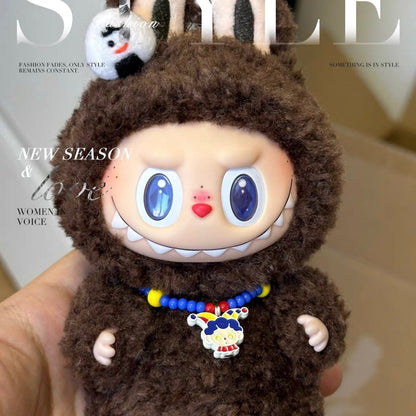 Toy figure in a brown outfit with a colorful necklace held in front of a magazine cover.