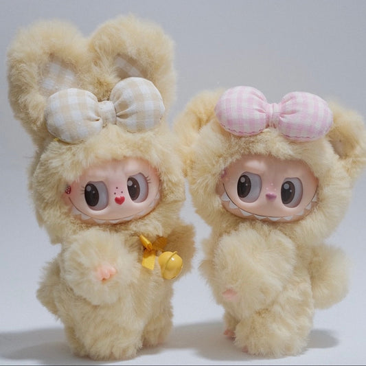 Two plush toys with large eyes and bows on a white background