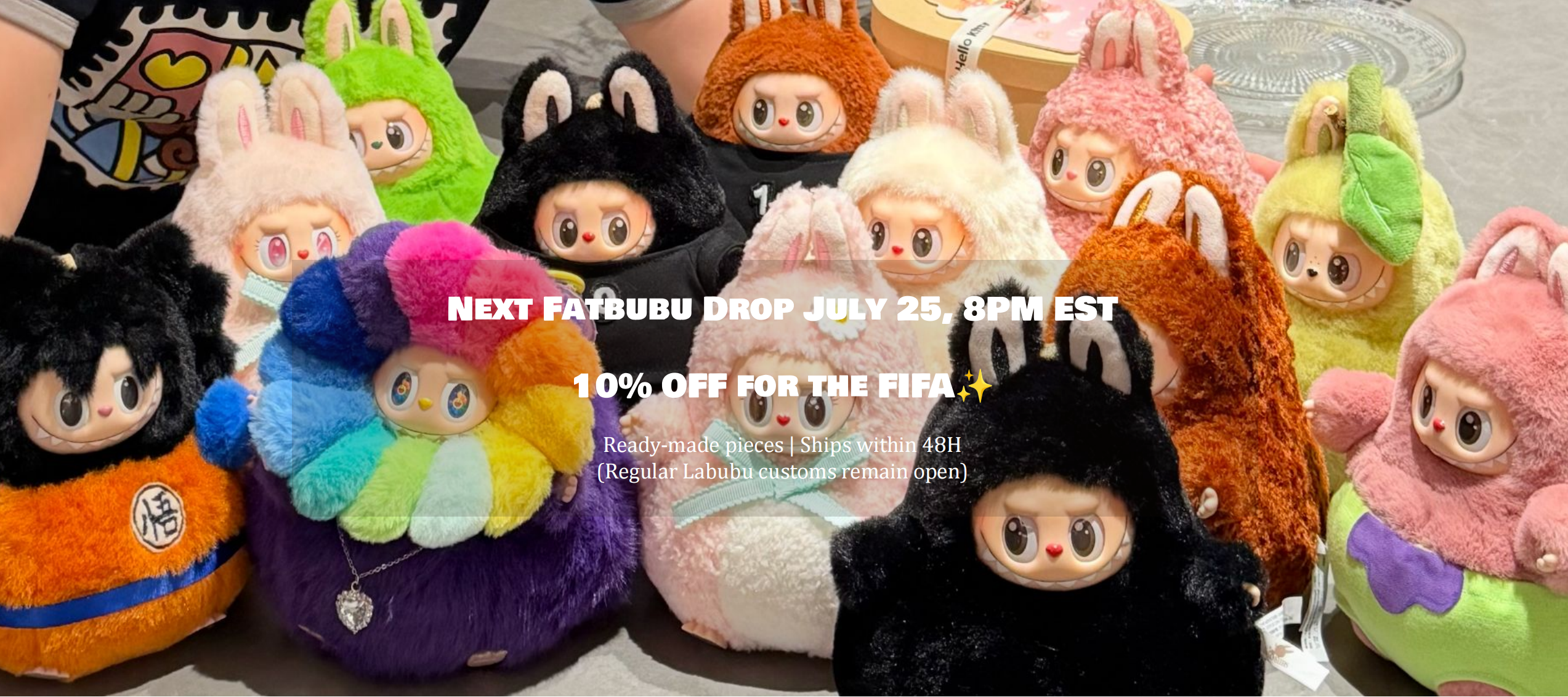 A group of colorful plush character toys arranged together on a surface, with overlaid promotional text reading 'NEXT FAFBUBU DROP JULY 25, 8PM EST 10% OFF FOR THE FIFA :'. The products appear to be soft stuffed dolls with cartoon faces and varied outfits in black, white, pink, purple, orange, green, and blue.